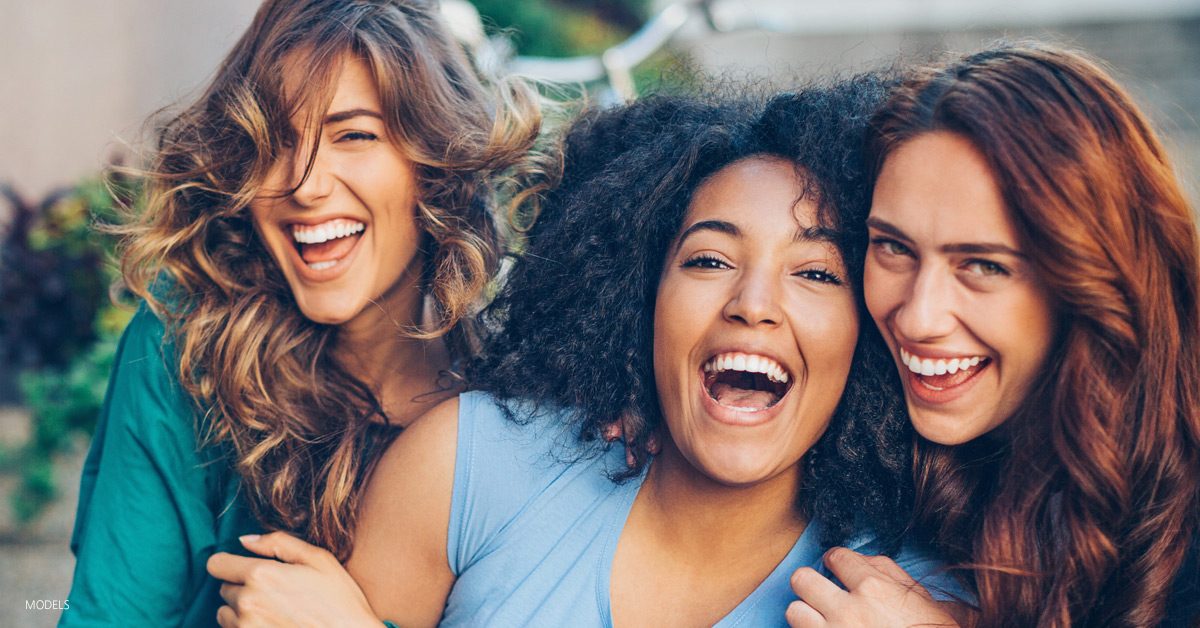 Young women laughing and discussing a mommy makeover procedure