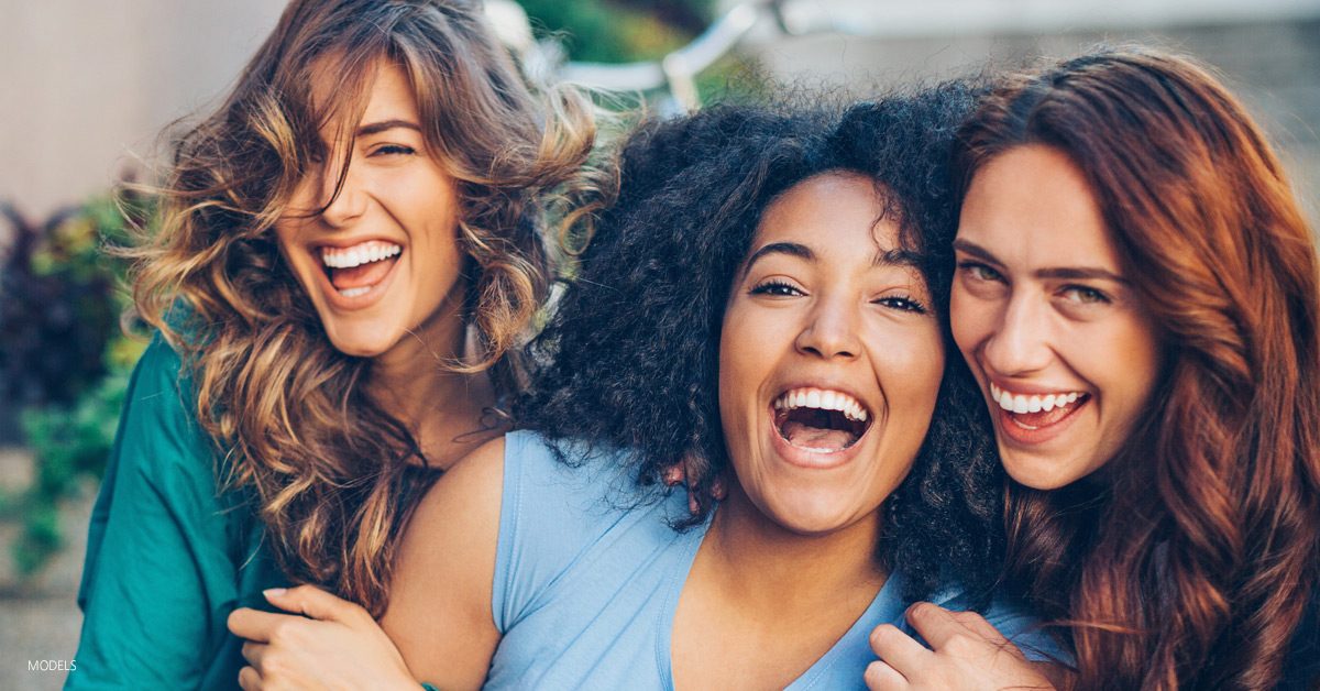 Young women laughing and discussing a mommy makeover procedure