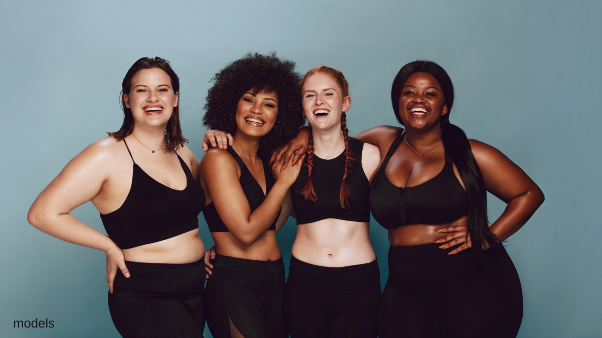 Four women standing together smiling. (Models)